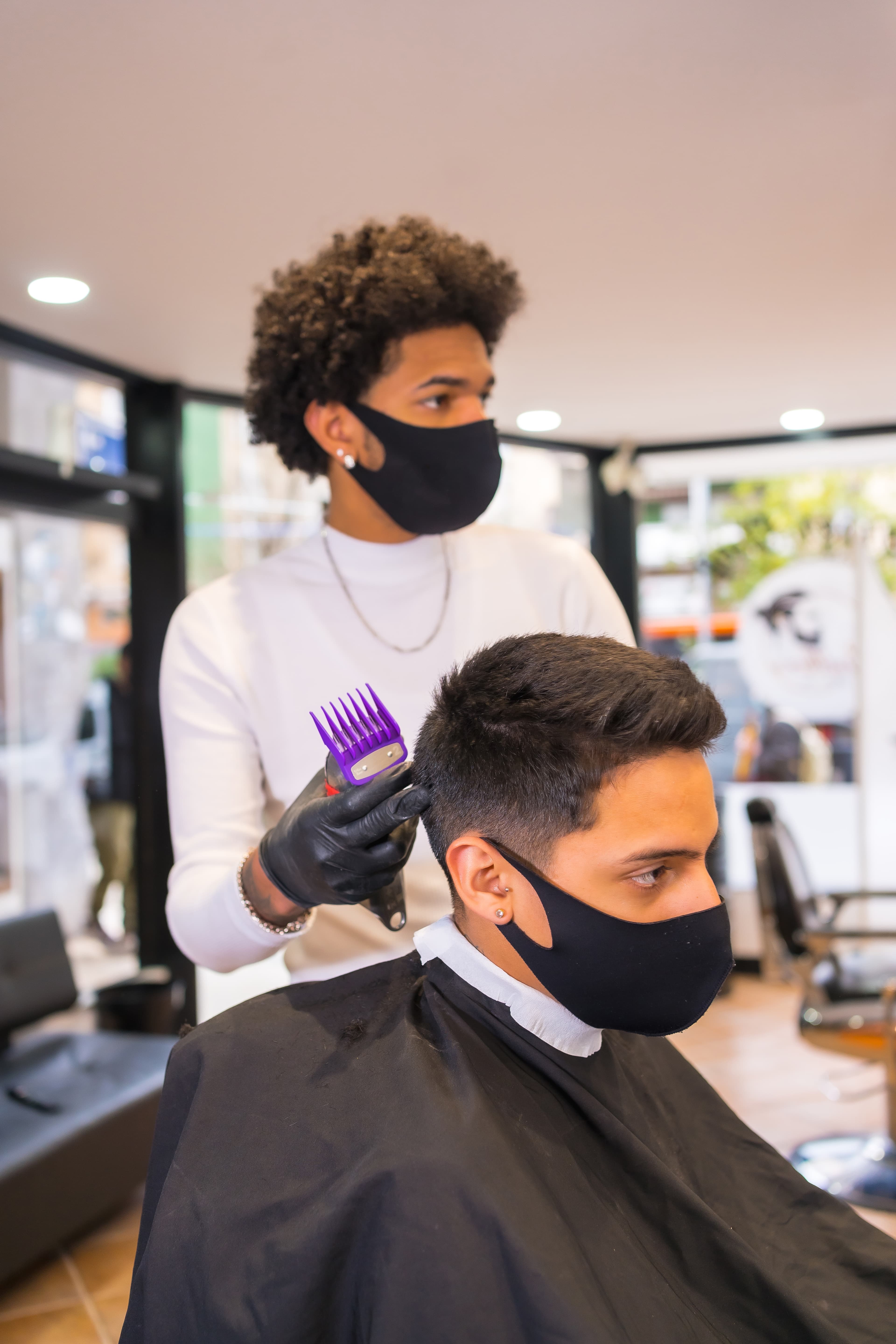 Barber instructor supporting a student